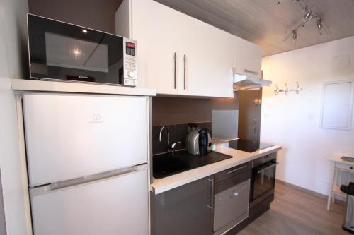 une cuisine avec un réfrigérateur en acier inoxydable et un micro-ondes dans l'établissement Le Balcon sur la Cité, à Carcassonne