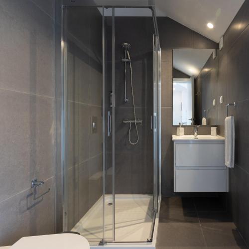 a bathroom with a shower and a toilet and a sink at Dona Emília Studio Apartments in Viana do Castelo