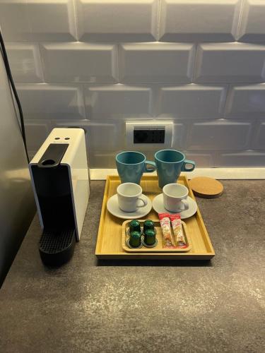 a tray with cups and cookies and a printer at CHANTTAL Luxury - UNIVERSITY in Bucharest