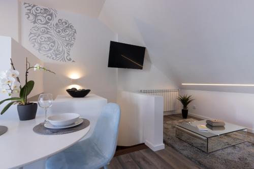 a white dining room with a white table and chairs at Dona Emília Studio Apartments in Viana do Castelo