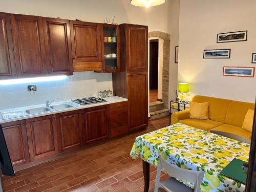 a kitchen with wooden cabinets and a table and a couch at Agriturismo Il Mulino delle canutole in Magione