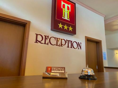 a reception sign on the wall of a hotel room at Hotel Termal in Geoagiu Băi