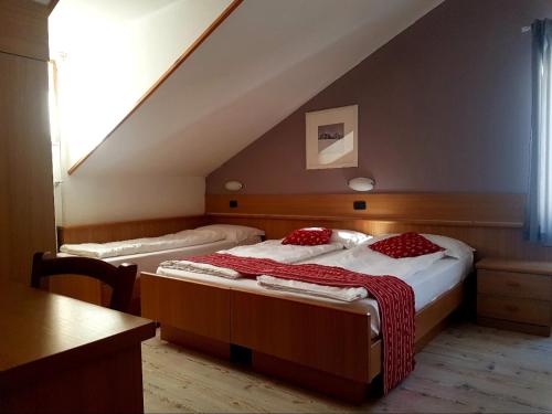 two beds in a room with a staircase at Ciasa Alpina Relax Hotel in Moena