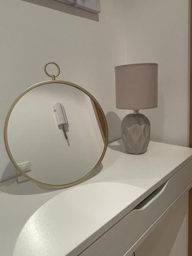 a mirror sitting on a counter next to a lamp at Apartamento N&S Carolinas in Vilagarcia de Arousa
