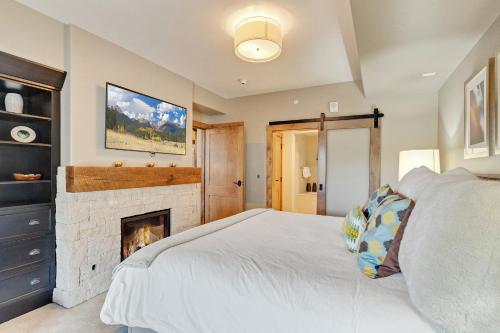 a bedroom with a bed and a fireplace at Edgemont 2306 - Luxury Condo - True Ski-in Ski-out Access & Winter Shuttle! in Steamboat Springs