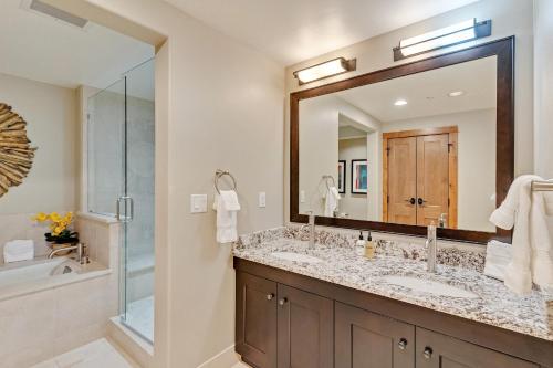 a bathroom with two sinks and a large mirror at Edgemont 2306 - Luxury Condo - True Ski-in Ski-out Access & Winter Shuttle! in Steamboat Springs
