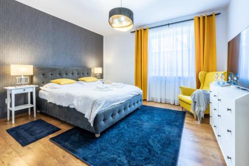 a bedroom with a large bed and a blue rug at Pokoje gościnne Beata (Niska1) in Krynica Morska