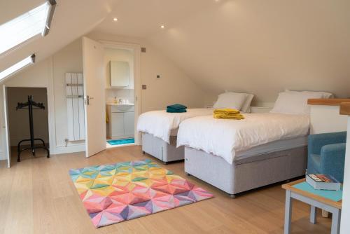 1 dormitorio con 2 camas y alfombra colorida en The Old Threshing Barn en Newark upon Trent
