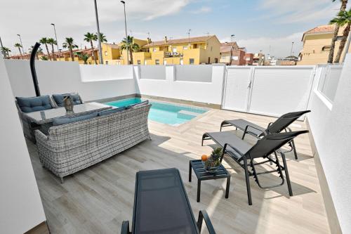 a patio with a couch and chairs on a roof at Villa Luna in San Pedro del Pinatar