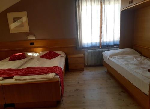 una camera con due letti e una finestra di Ciasa Alpina Relax Hotel a Moena