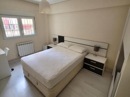 een slaapkamer met een wit bed en 2 nachtkastjes bij Coqueto piso buena ubicación in Santander