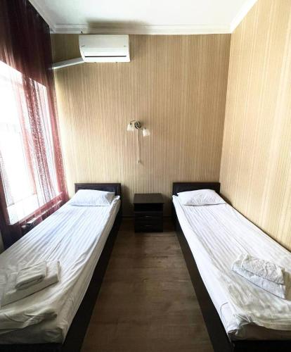 two twin beds in a room with two windows at Apart-Hotel City Center Contrabas in Lviv