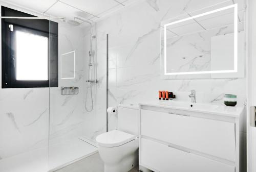 a white bathroom with a toilet and a shower at Villa Luna in San Pedro del Pinatar