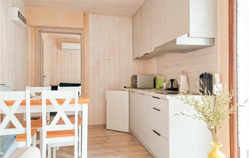 a kitchen with white cabinets and a table and chairs at Nice Home In Kladno With Wifi in Pleśna