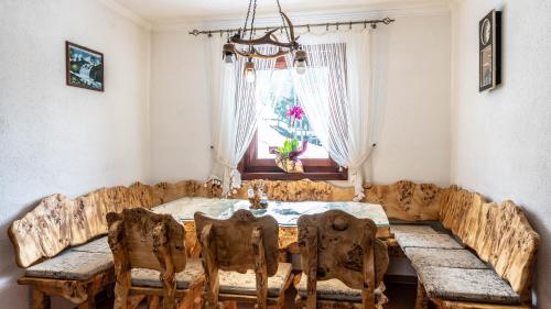 a dining room with a wooden table and chairs at Vila Seka in Kopaonik