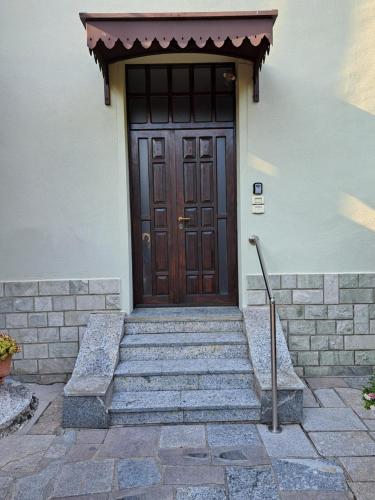 una puerta de madera con escaleras delante de un edificio en Green & Blue House, en Valbrona