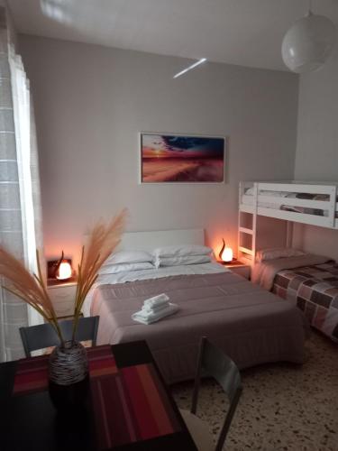 ein Schlafzimmer mit einem Bett und einem Tisch mit einer Pflanze in der Unterkunft GIOELE'S HOME in Scafati