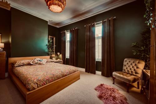 a bedroom with a bed and a chair and a chandelier at Beautiful B&B On The Park in Belfast