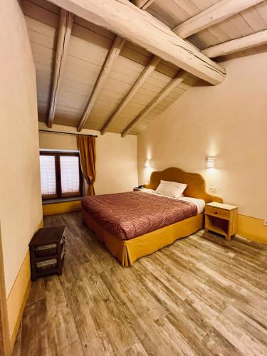 a bedroom with a bed and a wooden floor at Chaledo Milagro in Ruino