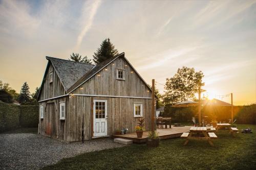 a barn with a picnic table in the yard at Auberge de l'Ouest in Deschambault