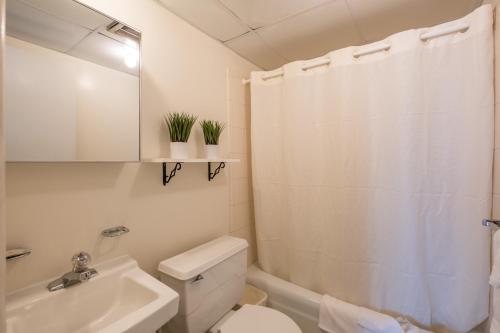 ein weißes Bad mit einem WC und einem Waschbecken in der Unterkunft Tahiti Inn in Ocean City