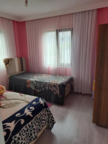 een kamer met 2 bedden en een raam bij ORTAKÖY VİLLA in Macka