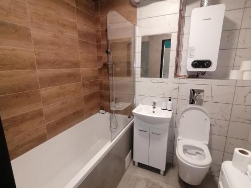 a bathroom with a toilet and a tub and a sink at Alicja apartament in Siemianowice Śląskie