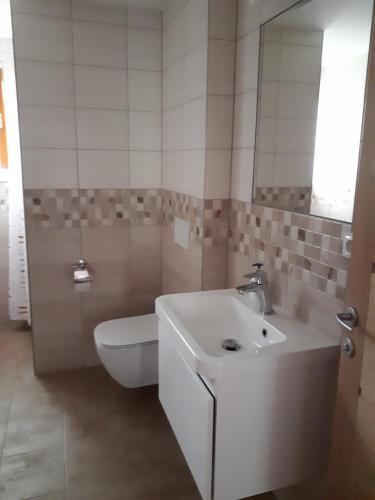 bagno con servizi igienici bianchi e lavandino di Depandance Blatov a Praga