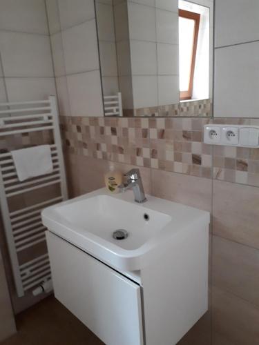 W łazience znajduje się biała umywalka i lustro. w obiekcie Depandance Blatov w Pradze
