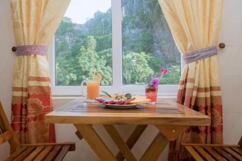 a table with a bowl of fruit and a window at HOA PHUONG PHONG NHA Hotel in Phong Nha