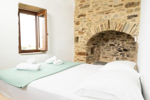 a bedroom with a bed and a stone fireplace at Nature Friendly Dame in Mési