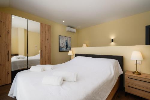 um quarto com uma cama branca e um espelho em Villa Istra Maružini by Solis Porec em Maružini
