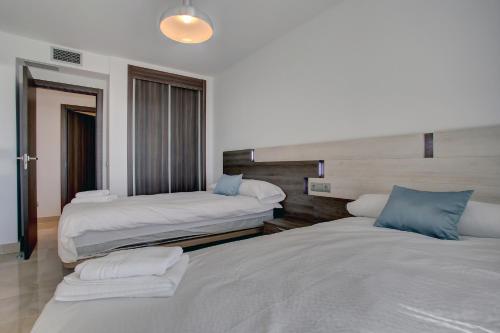 a bedroom with two beds with blue pillows at Aqua Apartments Vento, Marbella in Marbella