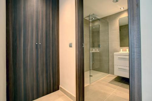 a bathroom with a shower and a glass door at Aqua Apartments Vento, Marbella in Marbella