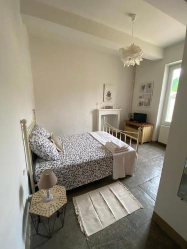 Dormitorio blanco con cama y mesa en Aux pieds tanques, en Barbentane