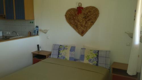 a bedroom with a heart hanging on the wall at Galini Apartments in Palekastron