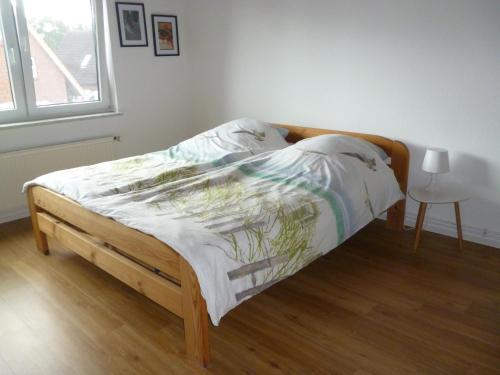 1 cama con marco de madera en un dormitorio en Strandnahe Ostsee Ferienwohnung im Ostseebad Schönberg Höhndorfer Tor 8, en Schönberg in Holstein