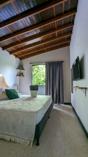 a bedroom with a large bed and a window at UKU INN in Medellín