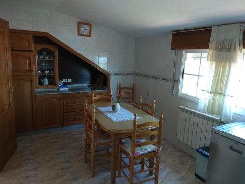 a kitchen with a table and chairs and a television at Apartamento O CASAL in O Grove