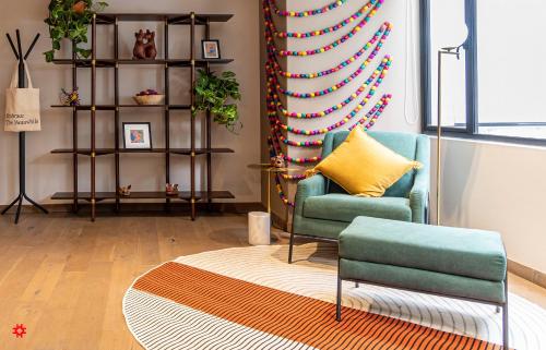 a living room with a chair and a rug at Casa Anatole France by Kukun in Mexico City