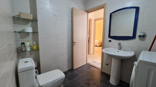 a bathroom with a toilet and a sink and a mirror at Apartment in Qerret in Golem