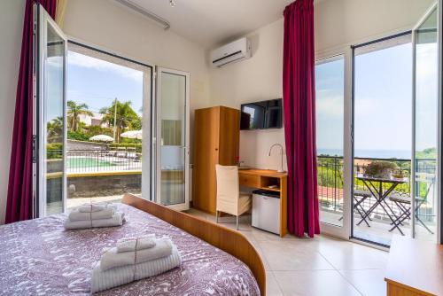 een slaapkamer met een bed en uitzicht op de oceaan bij Affittacamere villa Antonio in Aci Castello