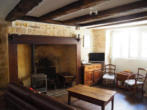 sala de estar con sofá y chimenea en Maison de La LAFONE, en Domme