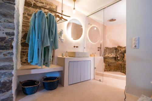 ein Badezimmer mit einem Waschbecken und einer Dusche mit Spiegeln in der Unterkunft Private Pool Dame in Mési