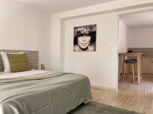 a bedroom with a bed and a painting on the wall at Pavillon de l’Étang in Châteauneuf-du-Rhône