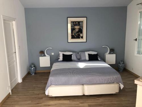 une chambre avec un grand lit aux murs bleus dans l'établissement Villa de vacances familiale avec jardin et piscine, à Cabrières-dʼAvignon