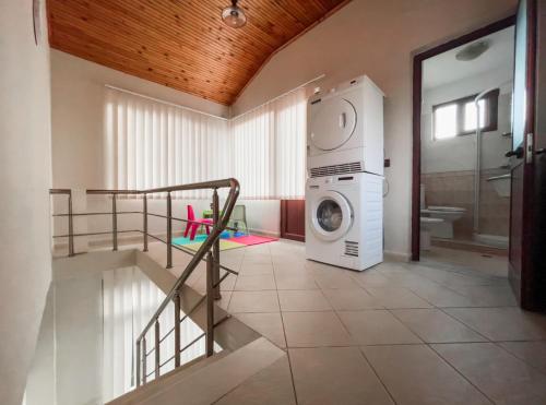 a bathroom with a washing machine in a room at Vila Kodra in Tirana