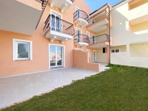 an apartment building with balconies and a yard at Affittimoderni La Maddalena - MADA25 in La Maddalena