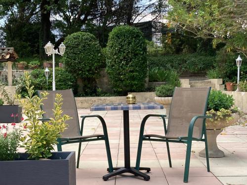 two chairs and a table in a garden at Pavillon de l’Étang in Châteauneuf-du-Rhône