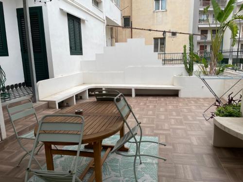 a patio with a wooden table and chairs at Dusmè in Taranto